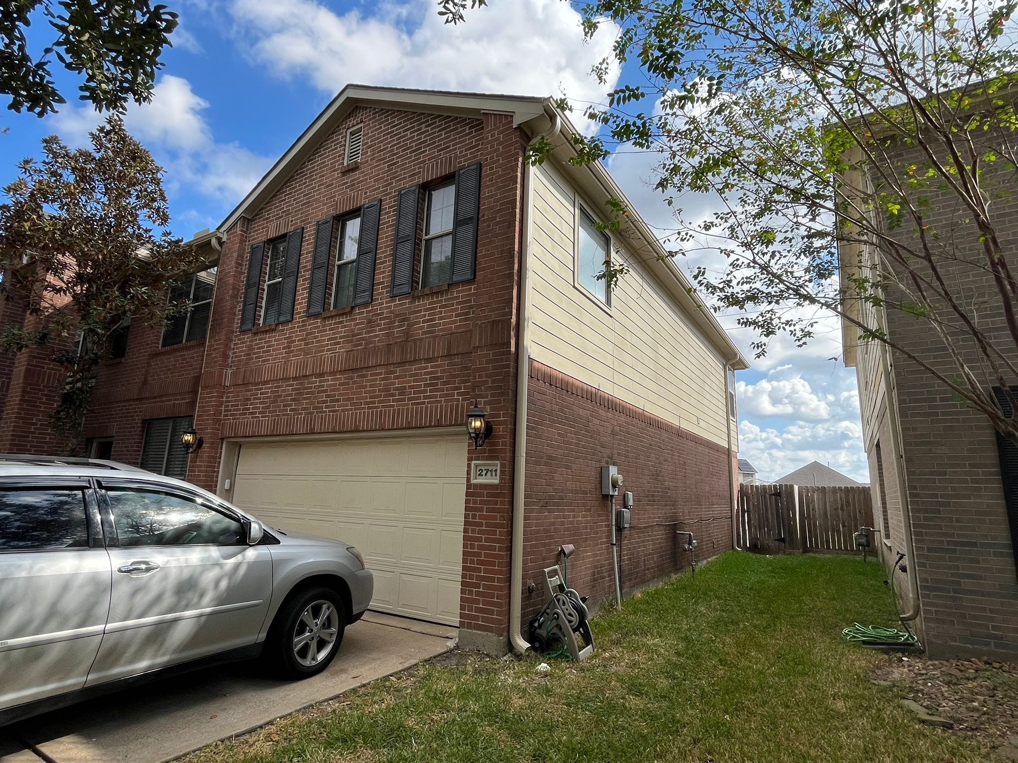 Finished brick townhome with white downspout