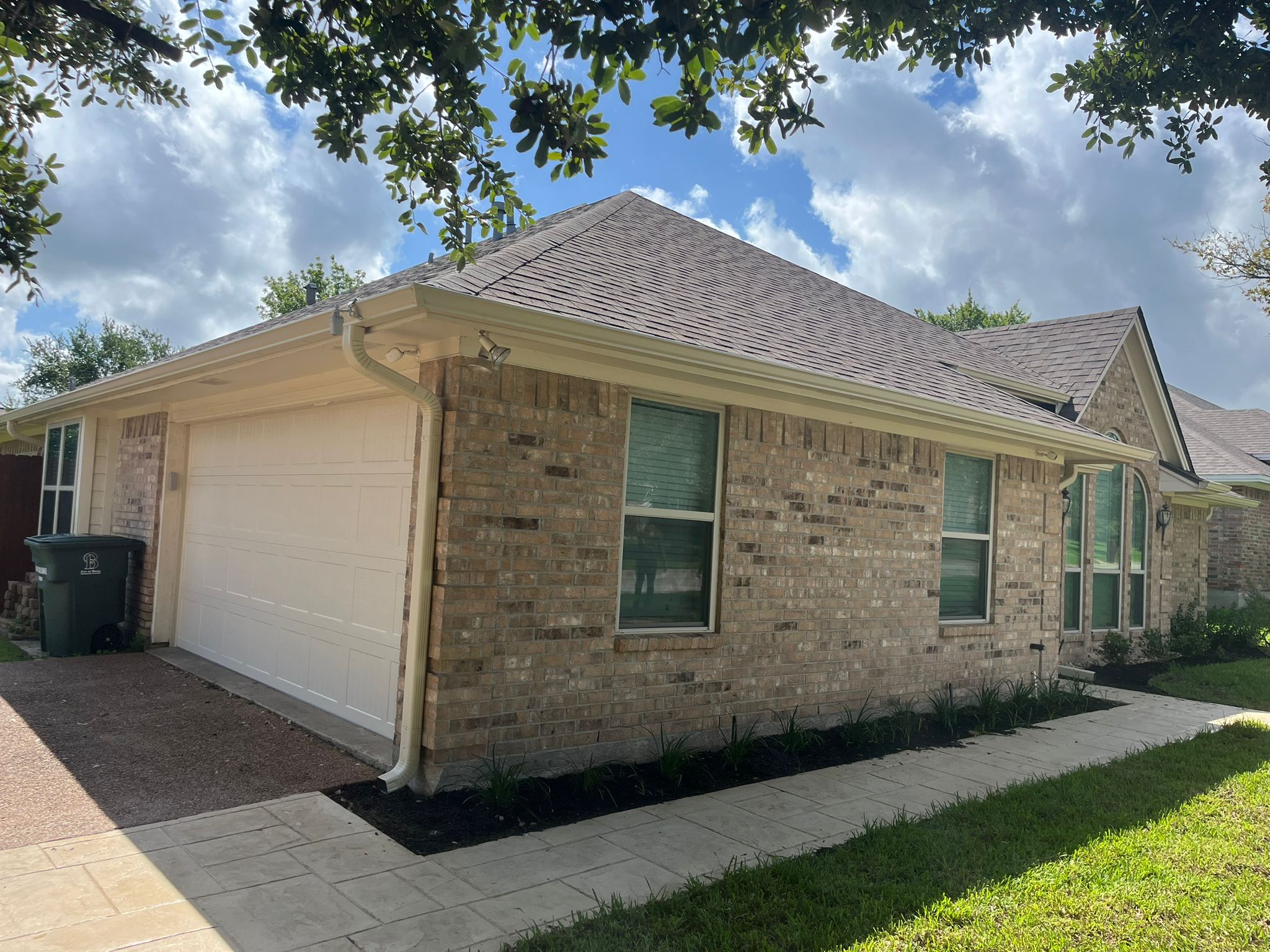 Finished brick home with seamless gutters and downspout