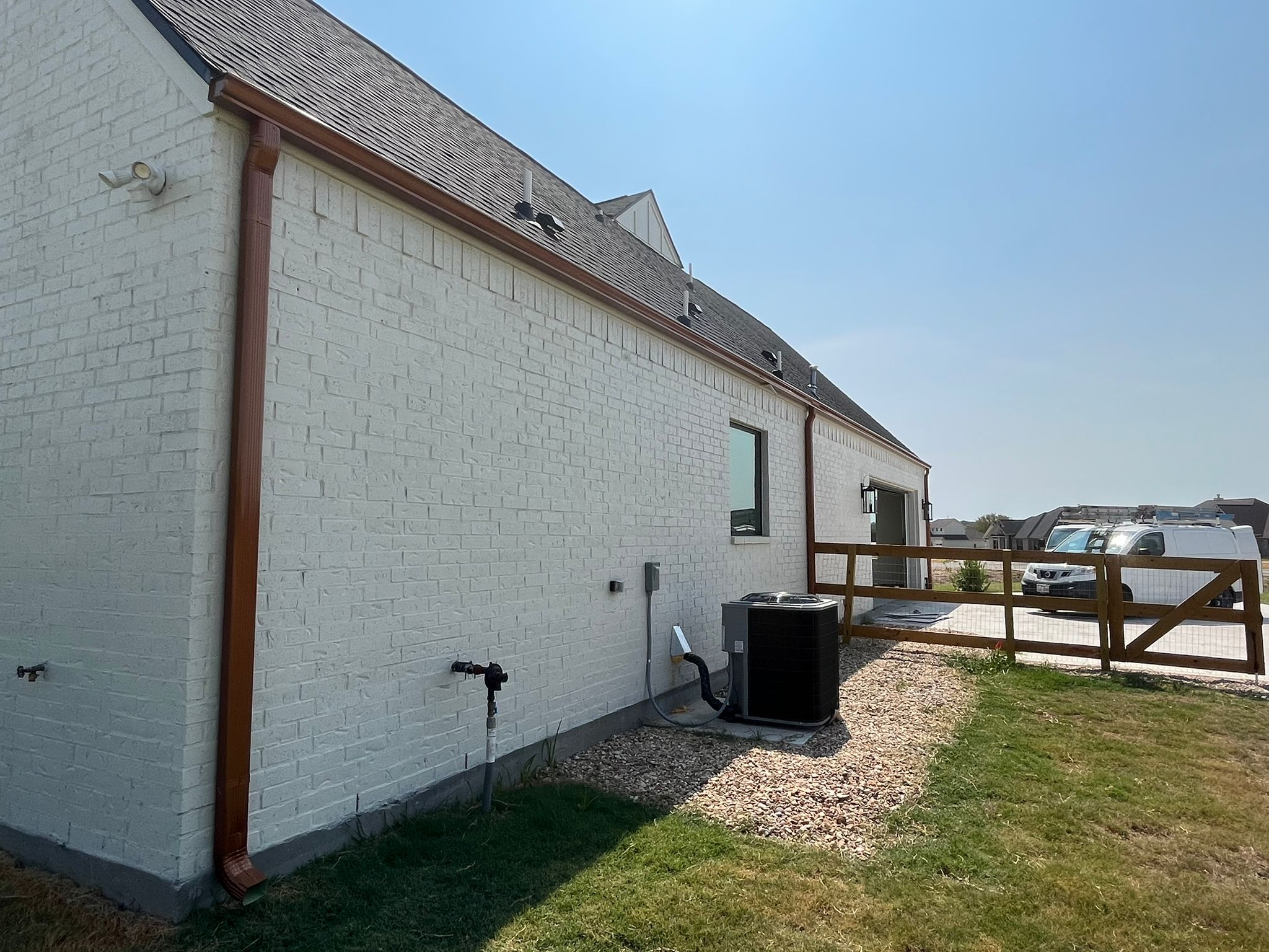 Copper gutter line on a new white-brick home