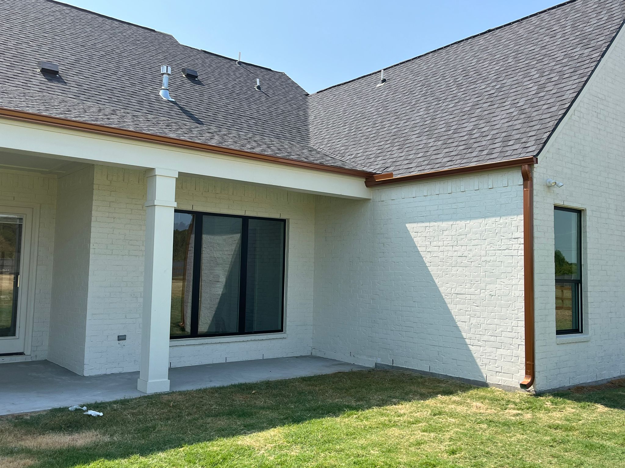 Copper downspout and seamless gutter line on a finished Houston-area home