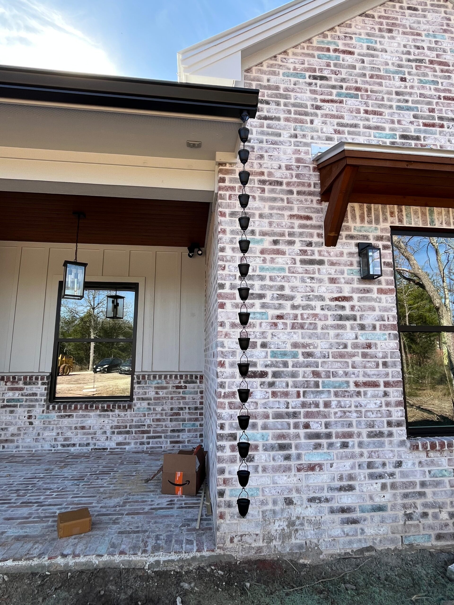 Black rain chain downspout on a finished home