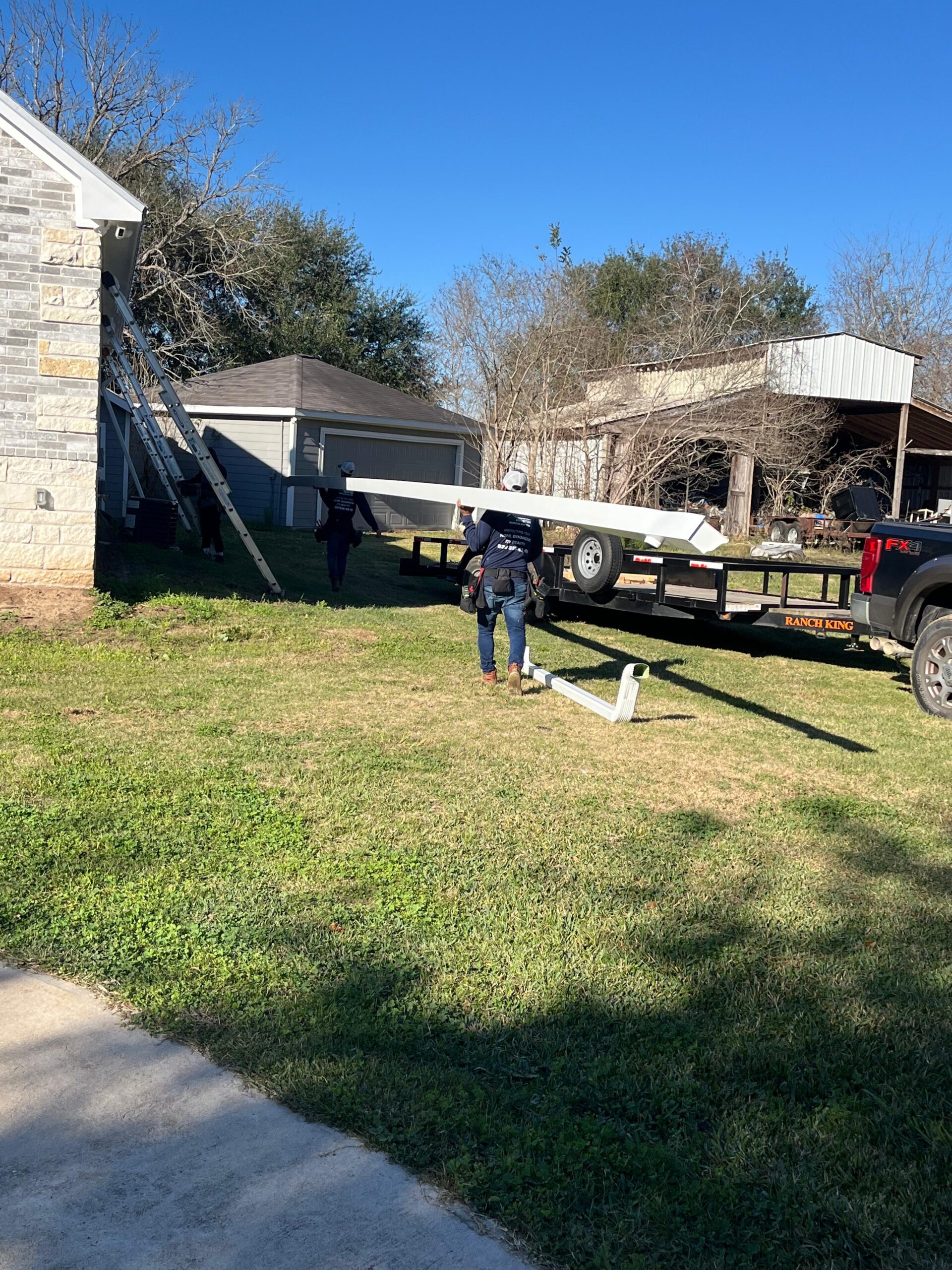 AC Houston technician installing white seamless gutters