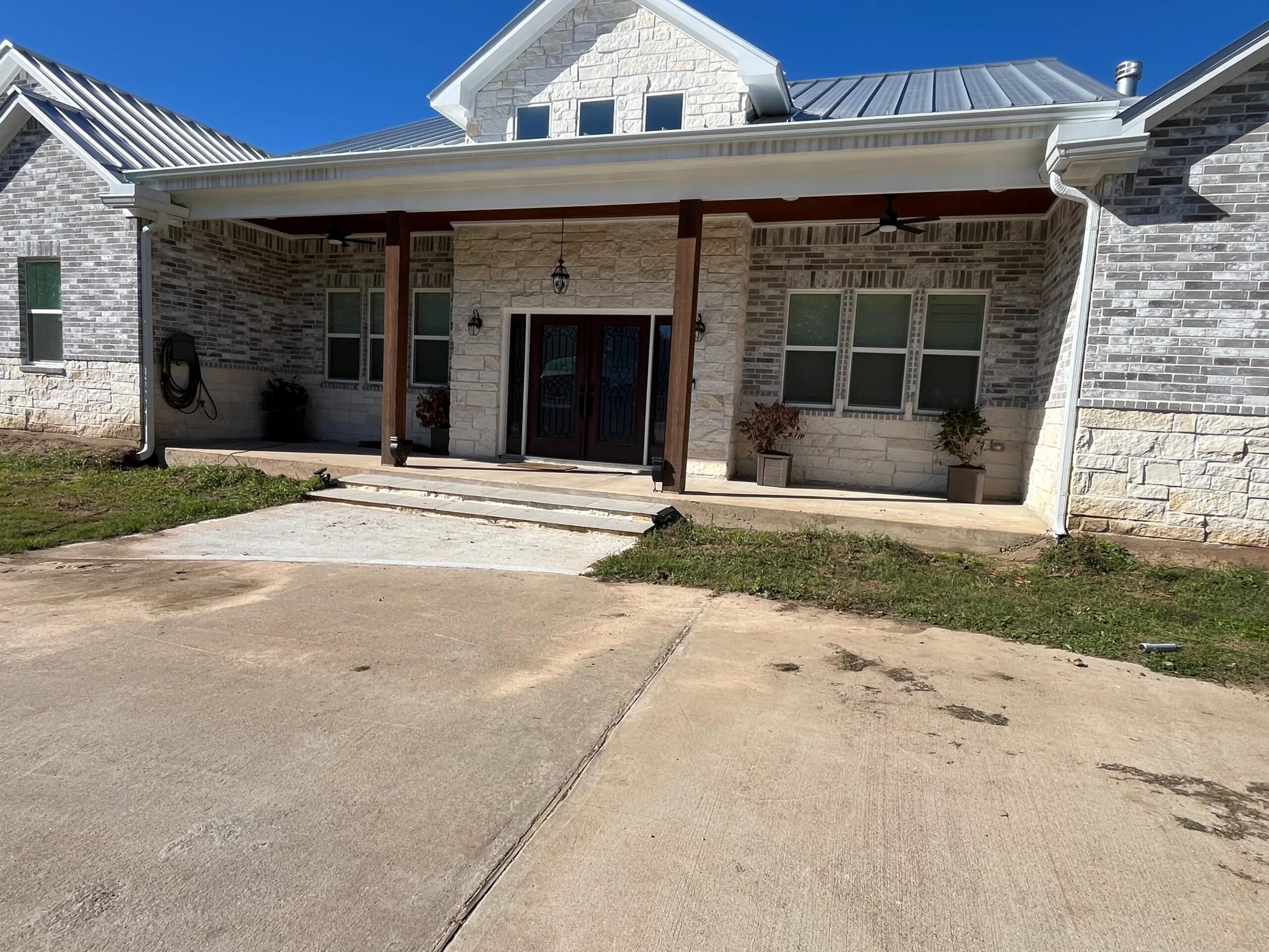 Finished stone home with white seamless gutters