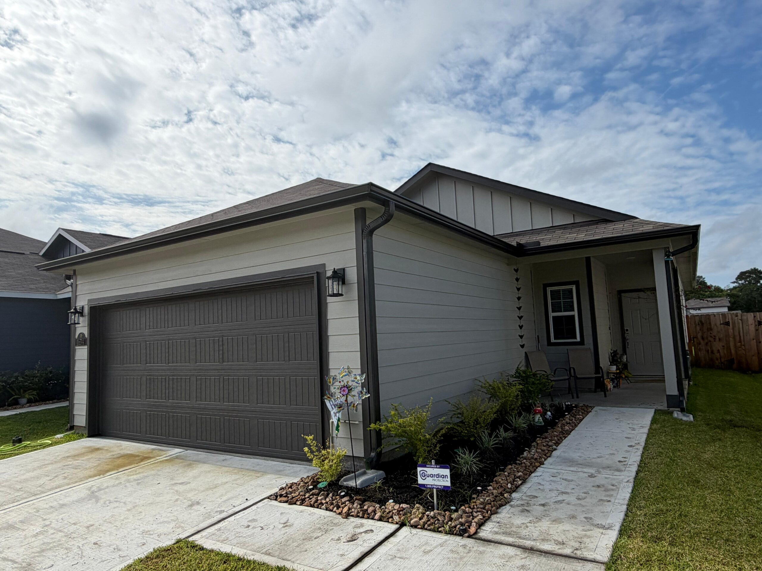 Finished home with white siding, garage, and seamless gutters