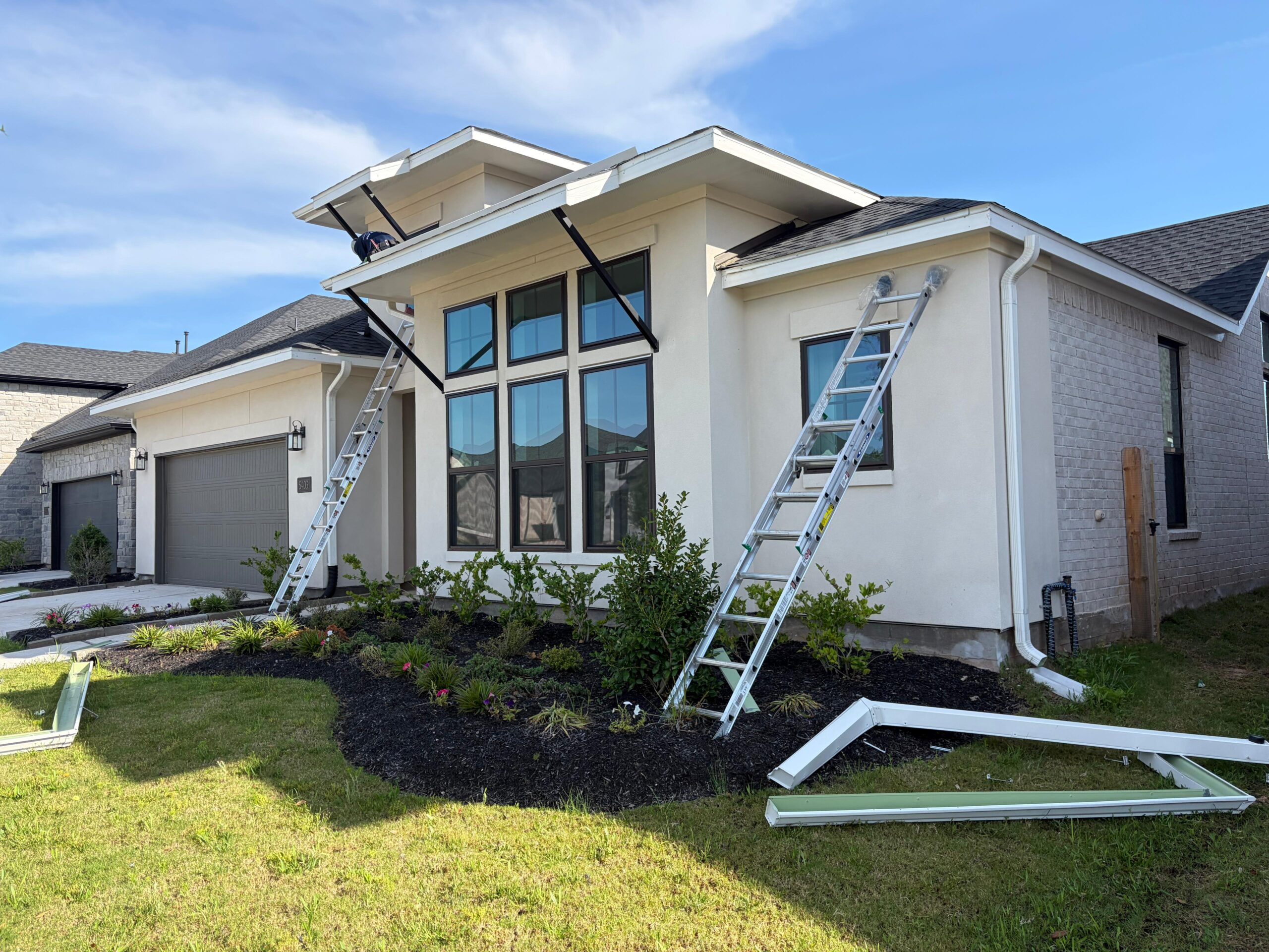 On-site seamless gutter installation along a finished roofline